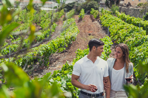 A couple waling through the vineyards.